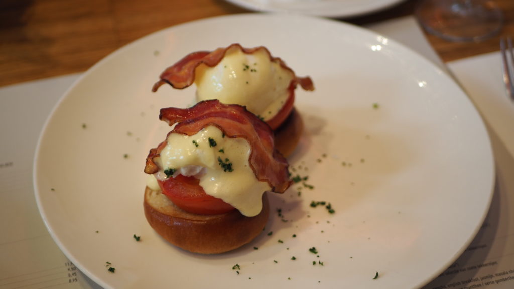 Eggs Benedict met bacon, tomaat en hollandaisesaus