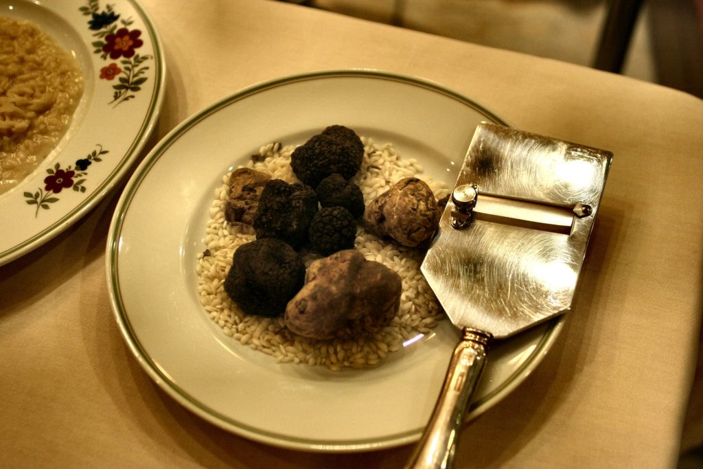 Truffel, de zogenaamde acquired taste, op een bord met een truffelschaaf