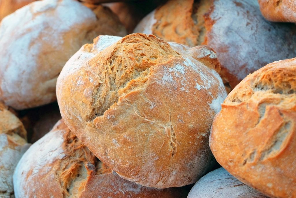 Brood: verschillende brood bollen, broden, op een stapel, mooi afgebloemd en gebarsten.